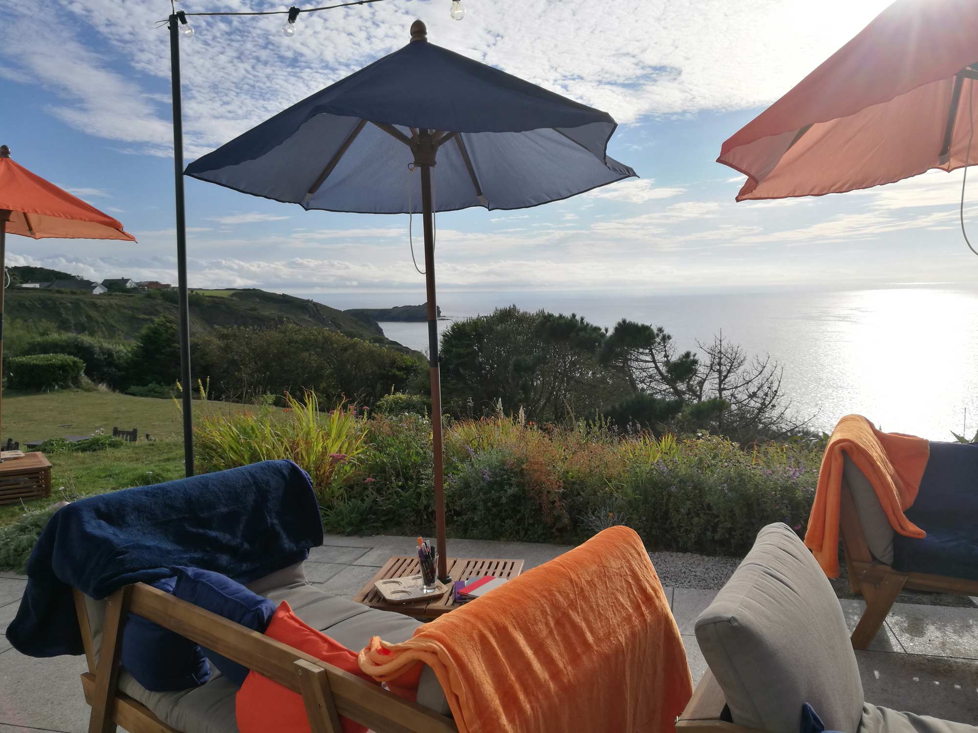 Tables and chairs set up on the terrace overlooking the sea